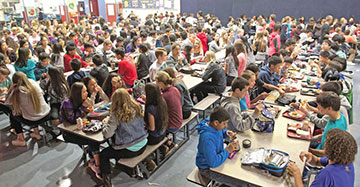 Eighth-grade students at Stoller Middle School eat lunch in a packed cafeteria.