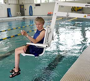 Bonnie Barksdale uses the ADA lift at Sunset Swim Center on NW Science Park Drive (directly north of Home Depot) to raise herself from the water. Swimmers can operate the lift themselves with the handheld control unit or request assistance from THPRD staff. Photo by Bob Wayt.
