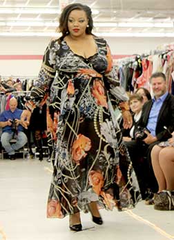 Model walks fashion show.