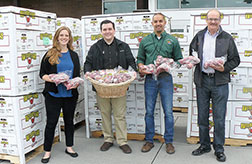 left to right Katie Pearmine, Oregon Food Bank; Steven Coppit, Market of Choice store manager; Sean Morrill, Charlie’s Produce; and Tim Corkill, First Fruits, with 11,900 lbs of apples. Eugene-based Market of Choice, with 11 stores, chose the Cedar Mill location this year for as the site for the statewide donation. The fruit will be distributed to local food banks based on their needs. 