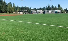 Looking across the artificial turf multi-sport field toward the new William Walker Elementary School