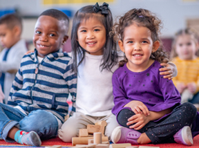 three children sitting and smiling